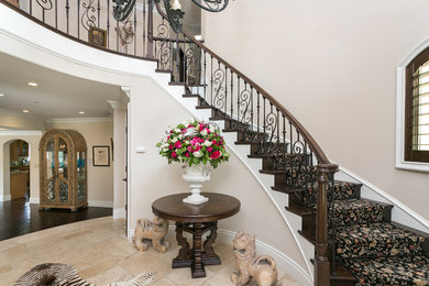 Mid-sized tuscan carpeted curved staircase photo in Los Angeles with wooden risers