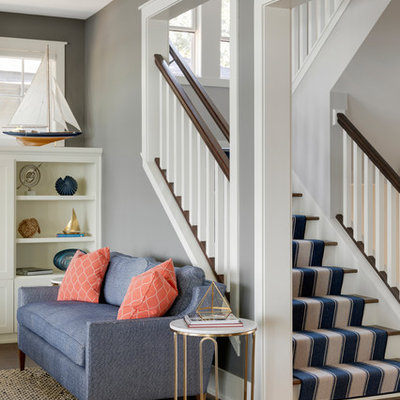 Example of a beach style carpeted u-shaped wood railing staircase design in Minneapolis with carpeted risers
