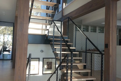 Стильный дизайн: большая лестница на больцах в современном стиле с деревянными ступенями без подступенок - последний тренд