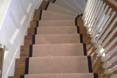 Example of a classic carpeted curved staircase design in New York with carpeted risers