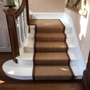 Cette image montre un très grand escalier victorien en U avec des marches en bois, des contremarches en bois et un garde-corps en bois.