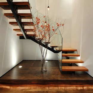 Large urban wooden u-shaped open and glass railing staircase photo in New York