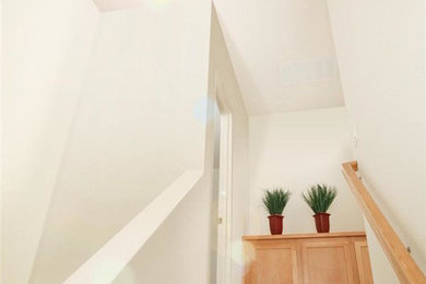 Diseño de escalera recta clásica renovada de tamaño medio con escalones enmoquetados, contrahuellas enmoquetadas y barandilla de madera