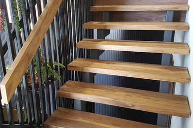 Réalisation d'un escalier sans contremarche flottant design avec des marches en bois et un garde-corps en bois.