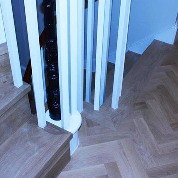 Solid walnut parquet floor in a herringbone pattern with matching staircase