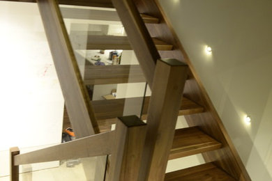Inspiration for a mid-sized modern wooden l-shaped open and glass railing staircase remodel in Other