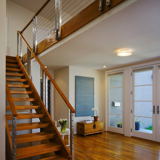 Diseño de escalera actual, sin contrahuella, con escalones de madera y barandilla de cable