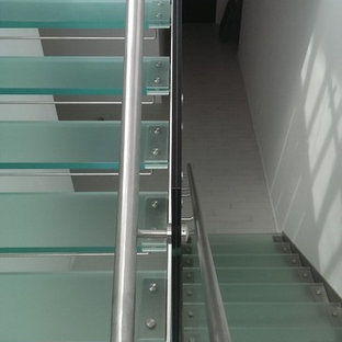 Foto di una scala a rampa dritta minimalista di medie dimensioni con pedata in vetro, nessuna alzata e parapetto in vetro