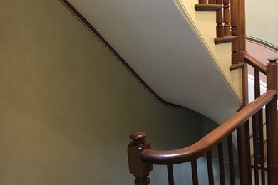 Ejemplo de escalera recta tradicional de tamaño medio con escalones de madera pintada, contrahuellas de madera pintada y barandilla de madera