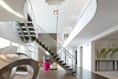 巨大なコンテンポラリースタイルのおしゃれな階段 (ガラスフェンス) の写真