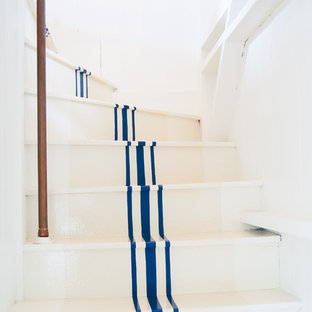 Idée de décoration pour un escalier courbe marin de taille moyenne avec des marches en bois peint et des contremarches en bois peint.