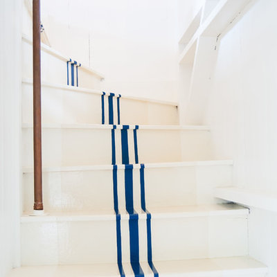 Mid-sized beach style painted curved staircase photo in Other with painted risers