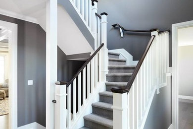 На фото: п-образная лестница в классическом стиле с ступенями с ковровым покрытием, ковровыми подступенками и деревянными перилами с