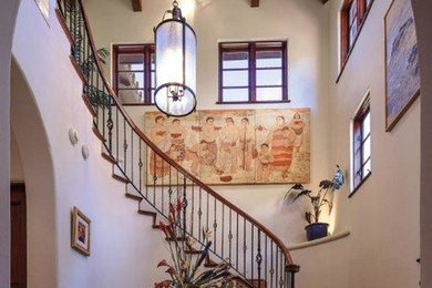 Идея дизайна: большая изогнутая деревянная лестница в средиземноморском стиле с деревянными ступенями
