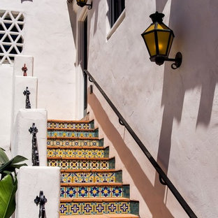 Foto di una scala a rampa dritta mediterranea con alzata piastrellata e pedata in terracotta