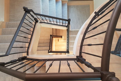 Example of a large arts and crafts curved metal railing staircase design in Other