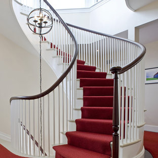 Example of a classic marble curved wood railing staircase design in Boston with painted risers