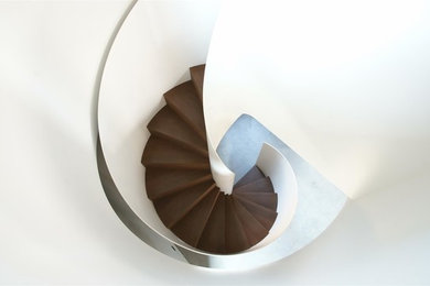 Ejemplo de escalera de caracol moderna grande con escalones de madera y contrahuellas de madera