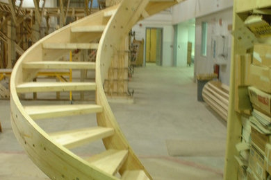 Foto de escalera de caracol de tamaño medio con escalones de madera y contrahuellas de madera