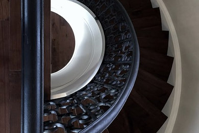 Diseño de escalera curva mediterránea grande con escalones de madera y contrahuellas de madera pintada