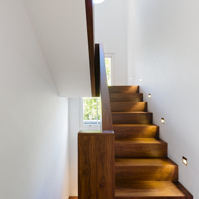 Example of a mid-sized trendy wooden u-shaped staircase design in London with wooden risers