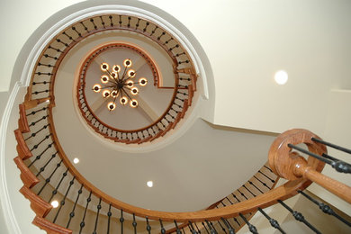 Elegant wooden curved staircase photo in DC Metro with wooden risers