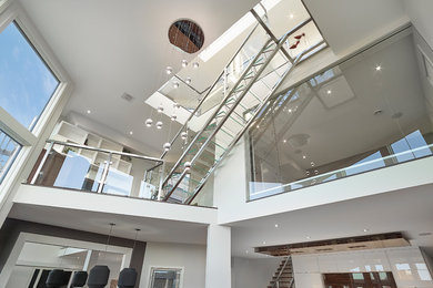 Inspiration for a modern glass straight metal railing staircase in Edmonton with metal risers.