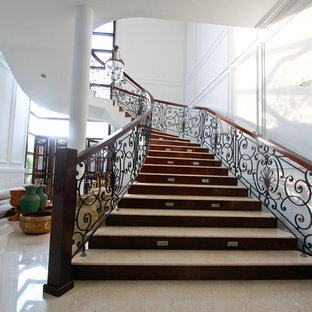 Gewendelte Mediterrane Treppe mit Travertin-Treppenstufen, Holz-Setzstufen und Stahlgeländer in Sonstige