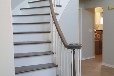 Inspiration pour un escalier peint courbe traditionnel de taille moyenne avec des marches en bois et un garde-corps en bois.