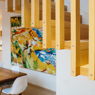 Esempio di una scala sospesa minimal di medie dimensioni con pedata in legno, alzata in legno e parapetto in legno