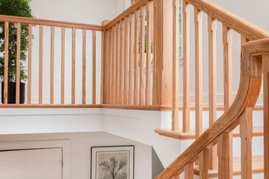 Idées déco pour un escalier éclectique en U de taille moyenne avec des marches en bois, des contremarches en bois et un garde-corps en bois.