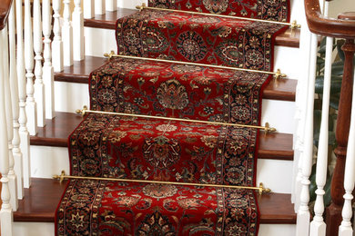 Diseño de escalera curva clásica de tamaño medio con escalones de madera, contrahuellas de madera pintada y barandilla de madera