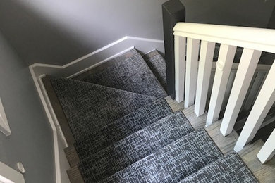Example of a trendy carpeted staircase design in Raleigh with carpeted risers