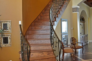 Modelo de escalera curva contemporánea grande con escalones de madera y contrahuellas de madera