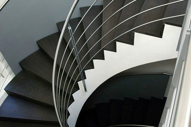 Ejemplo de escalera curva moderna grande con escalones de madera y contrahuellas de madera