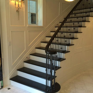 Immagine di una grande scala curva chic con pedata in legno verniciato, alzata in legno verniciato e parapetto in materiali misti