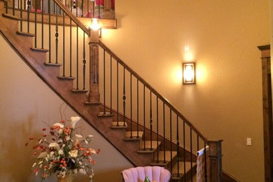 Cette photo montre un escalier courbe chic de taille moyenne avec des marches en bois, des contremarches en bois et un garde-corps en matériaux mixtes.