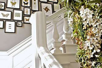 Imagen de escalera en L clásica grande con escalones enmoquetados, contrahuellas de madera, barandilla de madera y boiserie