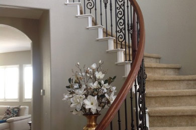 Example of a large classic carpeted curved staircase design in San Diego with carpeted risers