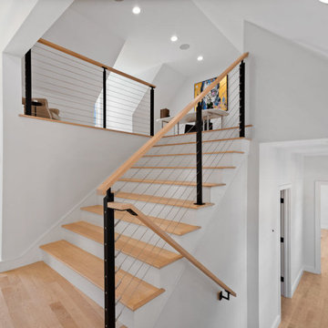 Staircase with cable railing leading to office loft