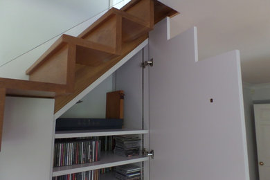 Imagen de escalera recta actual de tamaño medio con escalones de madera, contrahuellas de madera y barandilla de madera