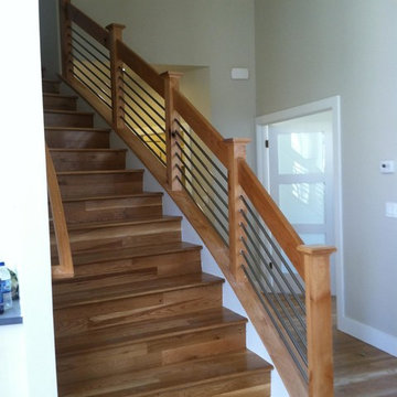 Staircase with wood flooring and cable railing