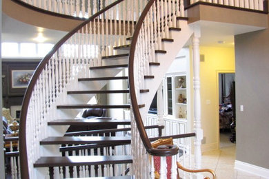 Diseño de escalera curva tradicional grande sin contrahuella con escalones de madera