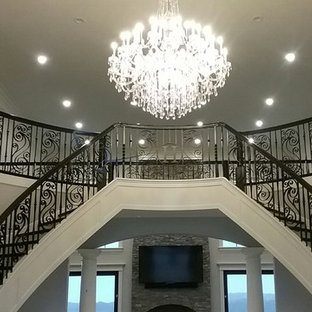 Foto di un'ampia scala a "U" american style con pedata in legno, alzata in legno verniciato e parapetto in materiali misti