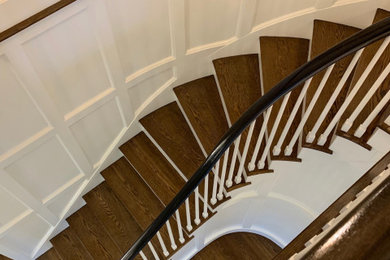 Ejemplo de escalera curva clásica renovada grande con escalones de madera, contrahuellas de madera pintada y barandilla de madera