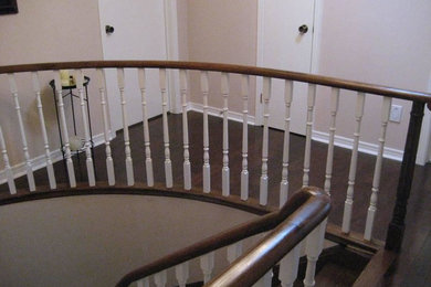 Diseño de escalera curva grande con escalones de madera y contrahuellas de madera