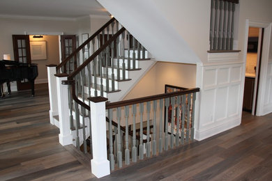 Foto de escalera en U tradicional renovada de tamaño medio con escalones de madera y contrahuellas de madera