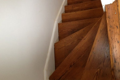 Imagen de escalera curva de tamaño medio con escalones de madera pintada y contrahuellas de madera