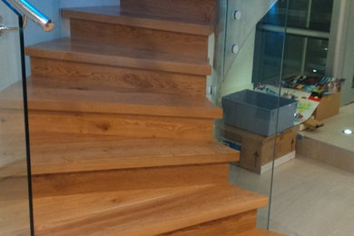 Diseño de escalera de caracol minimalista con escalones de madera y contrahuellas de madera