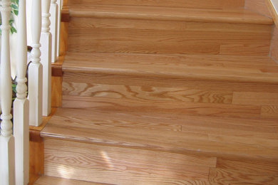 Example of a wooden curved staircase design in Vancouver with wooden risers
